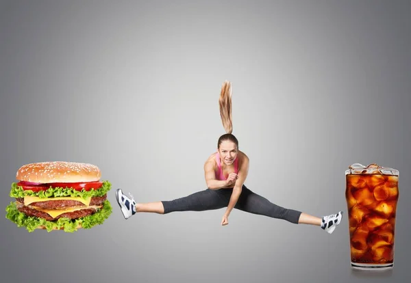 Mujer joven luchando contra la comida rápida — Foto de Stock