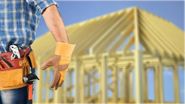 Worker with a tool belt on blurred background