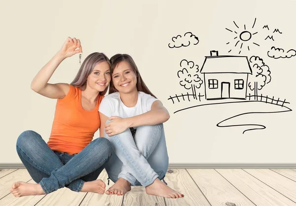 Dos Compañeras Cuarto Felices Sosteniendo Llave Sentadas Juntas — Foto de Stock