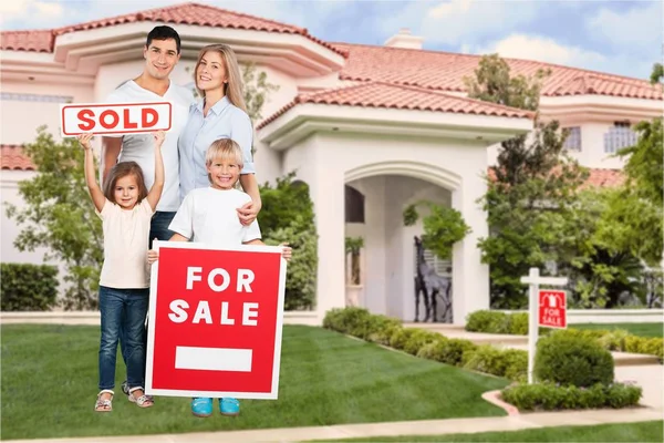 Glückliche Familie mit Verkaufsschild — Stockfoto