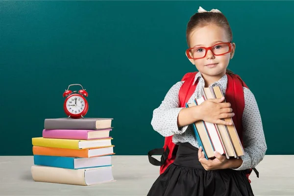 グリーン黒板背景に学校で赤いメガネ研究で若いかわいい女の子の写真 — ストック写真