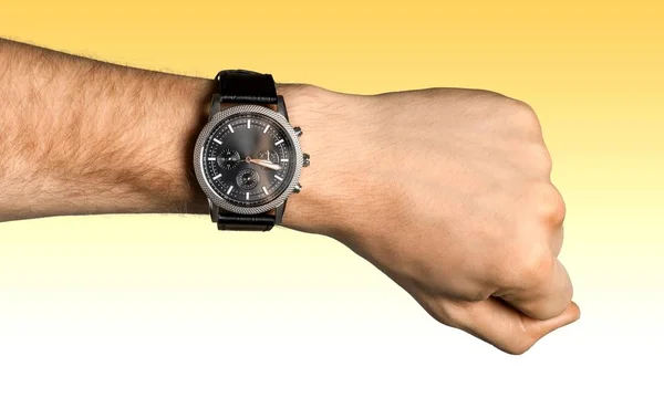 黄色の背景の時計と実業家の手のクローズ アップ — ストック写真