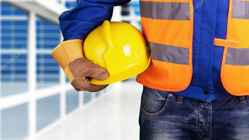 Worker man with helmet on blurred background 