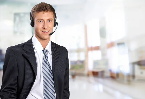 Ung Snygg Affärsman Kostym Använder Headsetet Mot Bakgrund — Stockfoto