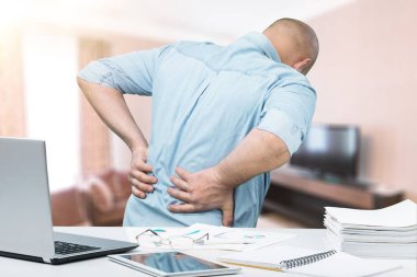 Sırtı ağrıyan bir iş adamı. 