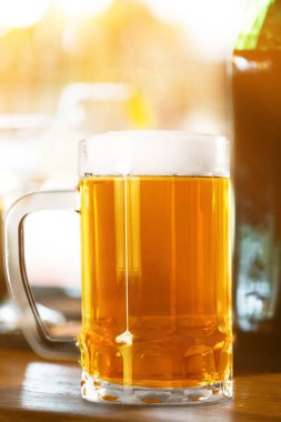 Masada ışık olan bir bardak bira.