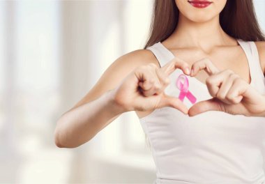 Göğüs kanserini desteklemek için pembe rozetli kadın. 