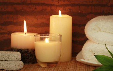 Mumlarla, havlularla ve taşlarla spa kompozisyonu