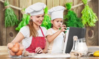 Mutlu anne ve kızı birlikte yemek pişiriyor. 