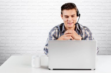 Kampüste dizüstü bilgisayarını kullanan yakışıklı bir üniversite öğrencisi.