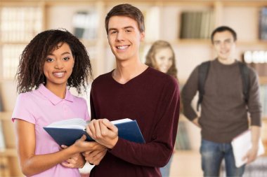 Mutlu öğrenciler kitap tutuyor. 