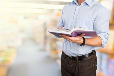 Kütüphane odasında kitap ve soyut bulanık kitaplık arkaplanı okunuyor