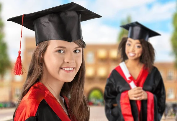 若いです女の子学生で卒業カップ上の大学背景 — ストック写真