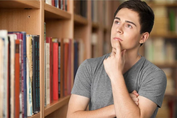Junger Mann Der Bibliothek Denkt Nach — Stockfoto