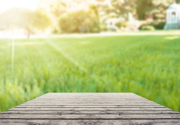 緑の草を背景に空の木のテーブル — ストック写真