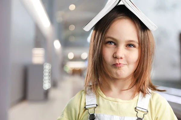 Kleines Mädchen Mit Einem Buch Auf Dem Kopf — Stockfoto