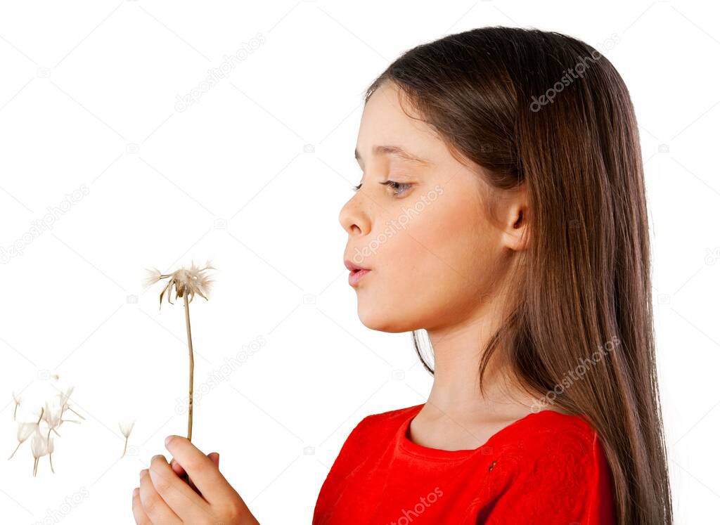 young girl blowing dandelion