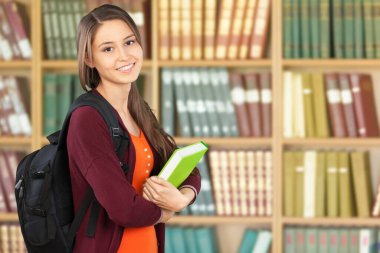 Kütüphanede kitabı olan bir kız öğrencinin portresi.