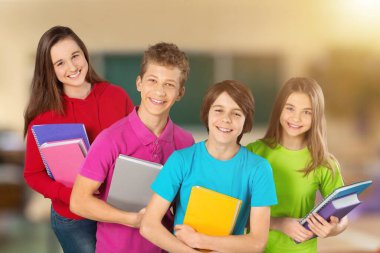 Okul üniformalı ve kitaplı bir grup öğrenci.