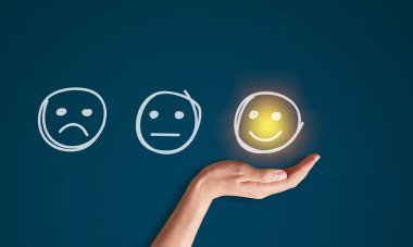 Siyah arka planda sarı bir gülücük tutan el.