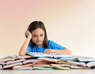 Masasında bir yığın kitap olan küçük bir kızın portresi.