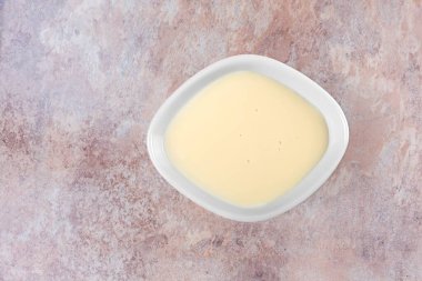 Küçük bir seramik kabın içinde bir kase beyaz yoğurt