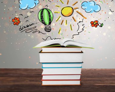 Ahşap masada renkli çizimleri olan bir yığın kitap.