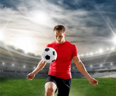 Stadyumda futbol topu olan genç adam.