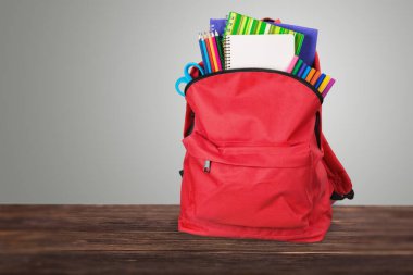 Ahşap arka plan üzerinde okul sırt çantası