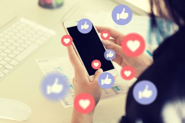 Sosyal medya simgelerine sahip akıllı telefon kullanan kadın