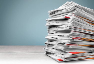 Arkaplanda gazete yığını, kapat