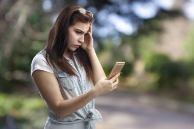 Akıllı telefon kullanan genç bir kadın. 