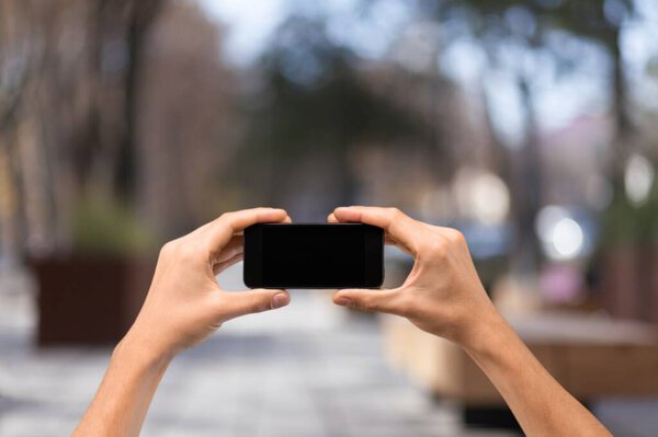 hands holding smartphone with blank screen