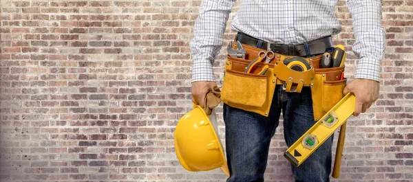 Young man worker with tool belt