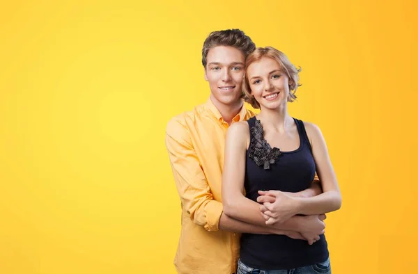 Feliz Joven Pareja Enamorada Abrazándose Sobre Fondo Amarillo — Foto de Stock