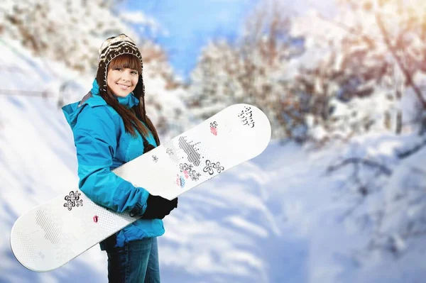 冬の背景にスノーボードを持つ若いかわいい女性の肖像画 — ストック写真