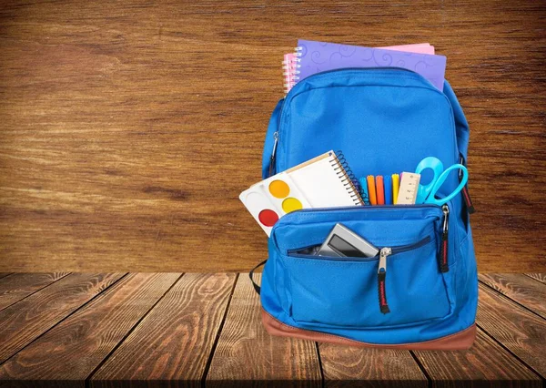 Mochila Escolar Con Papelería Sobre Fondo Madera —  Fotos de Stock