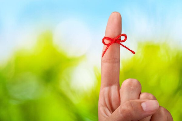 hand with thread on background, close up
