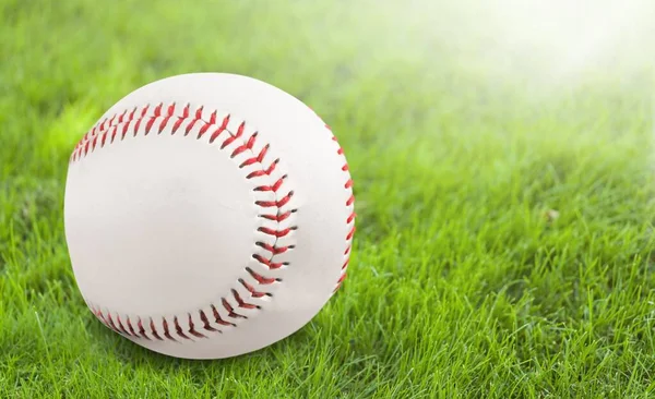 Yeşil Çimlerde Bir Beyzbol Topu — Stok fotoğraf