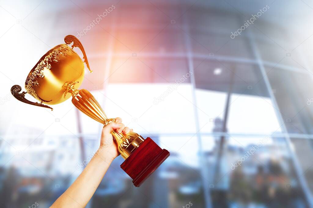 close up of human hands holding trophy