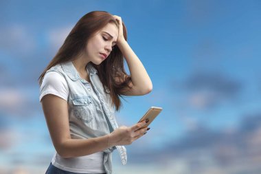 Akıllı telefon kullanan genç bir kadın.  