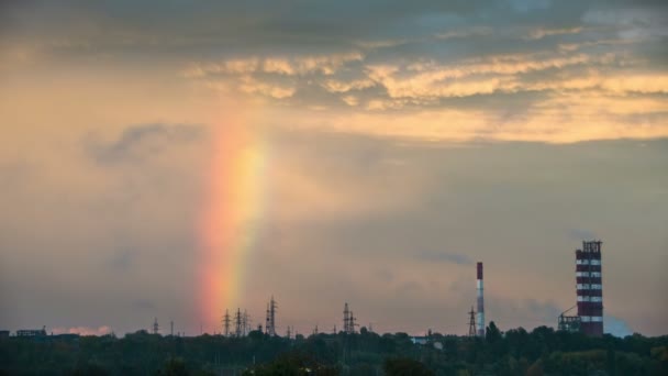 Wolken in de lucht en de regenboog gaan over de stad, gebouwen en Plant pijpen. Time-lapse — Stockvideo