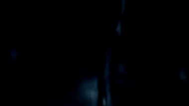 Su siyah arka plan üzerine saydam bir cam içine dökülür. Ağır çekim