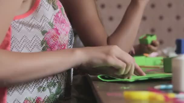 Дети делают ремесла из бумаги за столом, ручной работы — стоковое видео