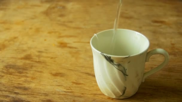 tasse de thé est coulé eau bouillante au ralenti 