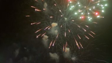 Gece gökyüzünde yanıp sönen havai fişekler. Ağır çekim
