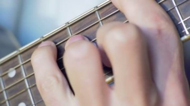 Adam akustik gitar çalıyor.