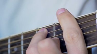 Adam akustik gitar çalıyor.