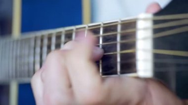 Adam akustik gitar çalıyor.