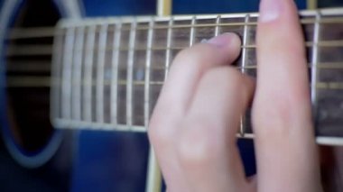 Adam akustik gitar çalıyor.